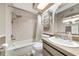 Cozy bathroom with a shower and tub combination, tiled walls, and ample lighting at 2070 59Th St, Sarasota, FL 34243