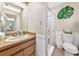 Bathroom vanity with adjacent step-in shower behind a shower curtain and decorative wall hanging at 2070 59Th St, Sarasota, FL 34243