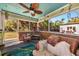 Cozy screened porch with wicker furniture, decorative fan, and tranquil outdoor views at 2070 59Th St, Sarasota, FL 34243