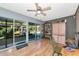 Bright sunroom featuring wood floors, sliding glass doors, and a ceiling fan for a cozy atmosphere at 2070 59Th St, Sarasota, FL 34243
