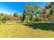 Large grassy yard surrounded by trees, complemented by a classic white fence at 2070 59Th St, Sarasota, FL 34243