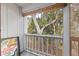 Condo balcony with wood railing and roller shade has wooded view at 2224 Bahia Vista St # E6, Sarasota, FL 34239