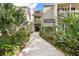 Exterior of condo building with walkway, lush greenery, and manicured landscaping at 2224 Bahia Vista St # E6, Sarasota, FL 34239
