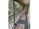 Long screened porch with wood floors, neutral paint and multiple colorful rugs at 2224 Bahia Vista St # E6, Sarasota, FL 34239