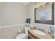 Half bath with tile floors, dark vanity, granite countertop and large mirror at 2403 Aspinwall St, Sarasota, FL 34237