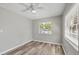 Bedroom with light gray walls, wood floors, ceiling fan and large bright window at 2403 Aspinwall St, Sarasota, FL 34237