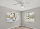 Bedroom with light gray walls, wood floors, ceiling fan and two bright windows at 2403 Aspinwall St, Sarasota, FL 34237