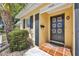 Inviting front entry with a unique door design and tiled porch at 2403 Aspinwall St, Sarasota, FL 34237