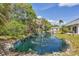 Picturesque pond with fountain, surrounded by lush trees, providing a serene and inviting outdoor space at 2403 Aspinwall St, Sarasota, FL 34237