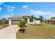 Beautiful single-story home featuring a well-manicured lawn, a two-car garage, and mature palm trees at 2523 Dixon Ter, Port Charlotte, FL 33981