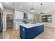 Modern kitchen with a blue island, white cabinets, stainless appliances, and stylish pendant lighting at 2523 Dixon Ter, Port Charlotte, FL 33981