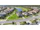 Aerial view of houses in a neighborhood, a pond, and a golf course in the distance at 25325 Longmeadow Dr, Punta Gorda, FL 33955