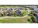 Stunning aerial view of homes surrounded by lush landscaping, golf course, and serene pond at 25325 Longmeadow Dr, Punta Gorda, FL 33955