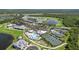 Community aerial view with tennis courts, clubhouse, pool, greenspace, parking and a serene lake at 25325 Longmeadow Dr, Punta Gorda, FL 33955
