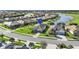 Aerial view of homes in a lakeside community featuring well-manicured lawns and a golf course at 25325 Longmeadow Dr, Punta Gorda, FL 33955