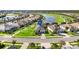 Aerial view of homes in a lakeside community featuring well-manicured lawns and a golf course at 25325 Longmeadow Dr, Punta Gorda, FL 33955