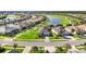 Aerial view of homes in a lakeside community featuring well-manicured lawns and a golf course at 25325 Longmeadow Dr, Punta Gorda, FL 33955