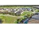 Gorgeous aerial view of homes with screened lanais, mature landscaping, pond, and golf course at 25325 Longmeadow Dr, Punta Gorda, FL 33955