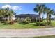 Beautifully landscaped backyard with lush lawn, colorful plants, and a screened-in lanai with a pool at 25325 Longmeadow Dr, Punta Gorda, FL 33955