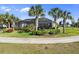Picture of a lush backyard with well-maintained lawn, pretty shrubs and trees, and a screened lanai at 25325 Longmeadow Dr, Punta Gorda, FL 33955