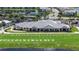 Beautiful shot of the clubhouse with a large green lawn and a lake at 25325 Longmeadow Dr, Punta Gorda, FL 33955