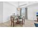 Dining area showcasing a glass table, ornate chairs, modern lighting, and wood-look tile floors at 25325 Longmeadow Dr, Punta Gorda, FL 33955