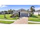 Charming single-story home featuring lush landscaping, brick driveway, and attached two car garage at 25325 Longmeadow Dr, Punta Gorda, FL 33955