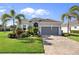 Charming single-story home featuring lush landscaping, brick driveway, and attached two car garage at 25325 Longmeadow Dr, Punta Gorda, FL 33955