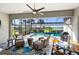 Inviting screened lanai with a ceiling fan, comfortable seating, and a view of the pool and picturesque backyard at 25325 Longmeadow Dr, Punta Gorda, FL 33955
