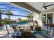 Relaxing screened lanai featuring comfortable seating, stylish decor, and views of the sparkling pool and lush landscape at 25325 Longmeadow Dr, Punta Gorda, FL 33955