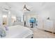Spacious primary bedroom with a television, view of the lanai and an ensuite bathroom at 25325 Longmeadow Dr, Punta Gorda, FL 33955