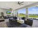 Stylish outdoor lounge with fireplace, TVs, and views of the golf course and lake at 25325 Longmeadow Dr, Punta Gorda, FL 33955