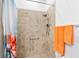Accessible shower area with tiled walls and a hand-held shower head at 25325 Longmeadow Dr, Punta Gorda, FL 33955