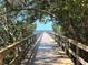 Scenic dock with wooden railing leading to waterfront views, framed by lush trees and blue skies, creating a serene walkway at 2625 Terra Ceia Bay Blvd # 206, Palmetto, FL 34221