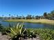 Beautiful golf course view with a scenic lake, lush green grass, palm trees, and charming homes at 2625 Terra Ceia Bay Blvd # 206, Palmetto, FL 34221