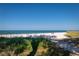 Picturesque beach view with white sand, clear blue water, and vibrant green vegetation at 3000 Gulf Dr # 3, Holmes Beach, FL 34217