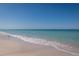 Calm beach scene with gentle waves lapping on the shore and a clear blue sky at 3000 Gulf Dr # 3, Holmes Beach, FL 34217