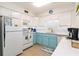 Updated kitchen featuring modern white appliances, ample counter space, and stylish blue bottom cabinets at 3000 Gulf Dr # 3, Holmes Beach, FL 34217