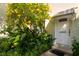 Charming laundry room entrance with landscaped garden and vibrant yellow flowers at 3000 Gulf Dr # 3, Holmes Beach, FL 34217