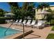 Inviting pool area with lounge chairs and tables surrounded by mature tropical landscaping at 3000 Gulf Dr # 3, Holmes Beach, FL 34217