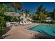 Inviting pool area with lounge chairs, umbrellas, and lush tropical landscaping at 3000 Gulf Dr # 3, Holmes Beach, FL 34217