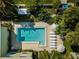 Overhead view of the community pool with sun loungers, umbrellas, and tropical landscaping at 3000 Gulf Dr # 3, Holmes Beach, FL 34217