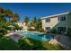 Community pool surrounded by lush tropical landscaping and lounge chairs for relaxation at 3000 Gulf Dr # 3, Holmes Beach, FL 34217
