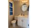 Cozy bathroom features a white vanity, toilet, mirror and blue shelving unit at 306 Barlow Ave # 77, Sarasota, FL 34232