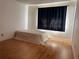 Bright bedroom features wood laminate flooring and a curtained window providing natural light at 306 Barlow Ave # 77, Sarasota, FL 34232