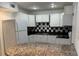 Bright kitchen featuring white cabinets, tiled backsplash, and updated appliances, creating a modern space at 306 Barlow Ave # 77, Sarasota, FL 34232