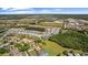 Stunning aerial view of home in a vibrant community, featuring lush greenery, a pond, and meticulously kept landscaping at 3617 Wild Blossom Pl, Parrish, FL 34219