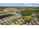 Incredible aerial view of home in a bustling community with a peaceful pond, lush trees, and manicured landscaping at 3617 Wild Blossom Pl, Parrish, FL 34219