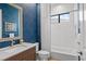Bathroom showcasing navy wallpaper and white tile tub surround at 3617 Wild Blossom Pl, Parrish, FL 34219