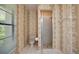 Charming bathroom with bamboo wallpaper, a shower, toilet, and tile flooring at 3640 Aster Dr, Sarasota, FL 34233